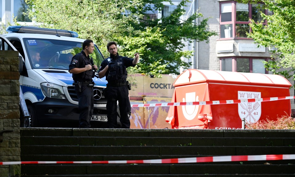 two police officers standing in front of a mercedes van