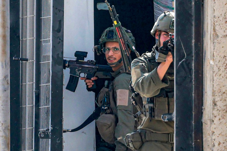 An Israeli soldier aims while positioned along a gateway during an army operation in Tulkarm in the north of the occupied West Bank on August 29, 2024. Israel on August 28 launched a large-scale operation in the occupied West Bank where the military said it killed Palestinian fighters, as the nearly 11-month-old Gaza war showed no signs of abating. (Photo by Jaafar ASHTIYEH / AFP) (Photo by JAAFAR ASHTIYEH/AFP via Getty Images)