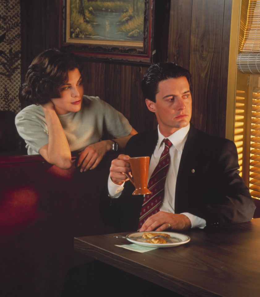 a man and a woman sit at a table with a plate of food