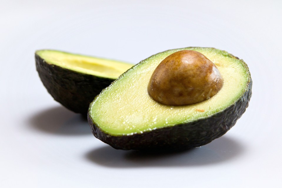 an avocado that has been cut in half with the seed still in it