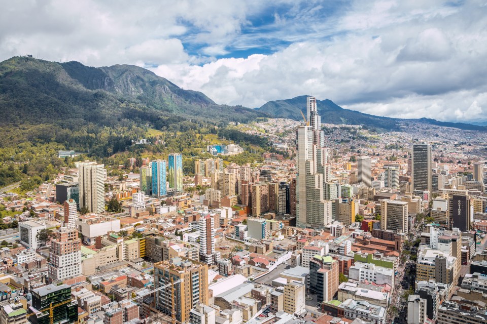 an aerial view of a city with mountains in the background