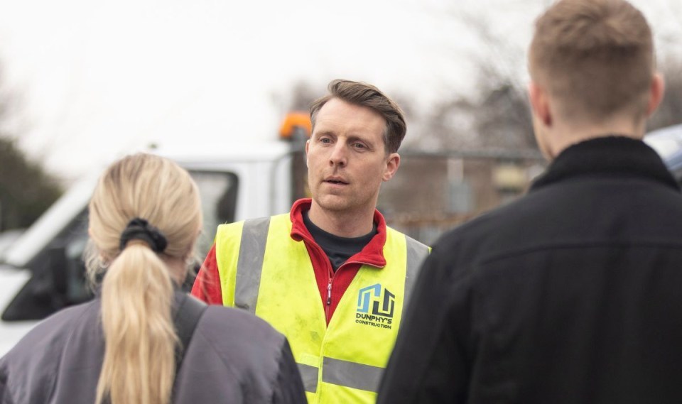 a man wearing a yellow vest that says company 's construction