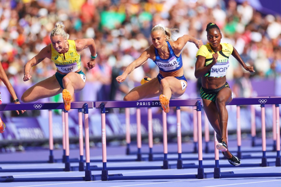 three female athletes are jumping hurdles at the paris olympics