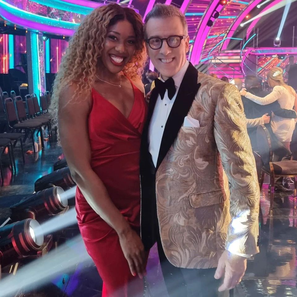 a man in a tuxedo and a woman in a red dress pose for a picture