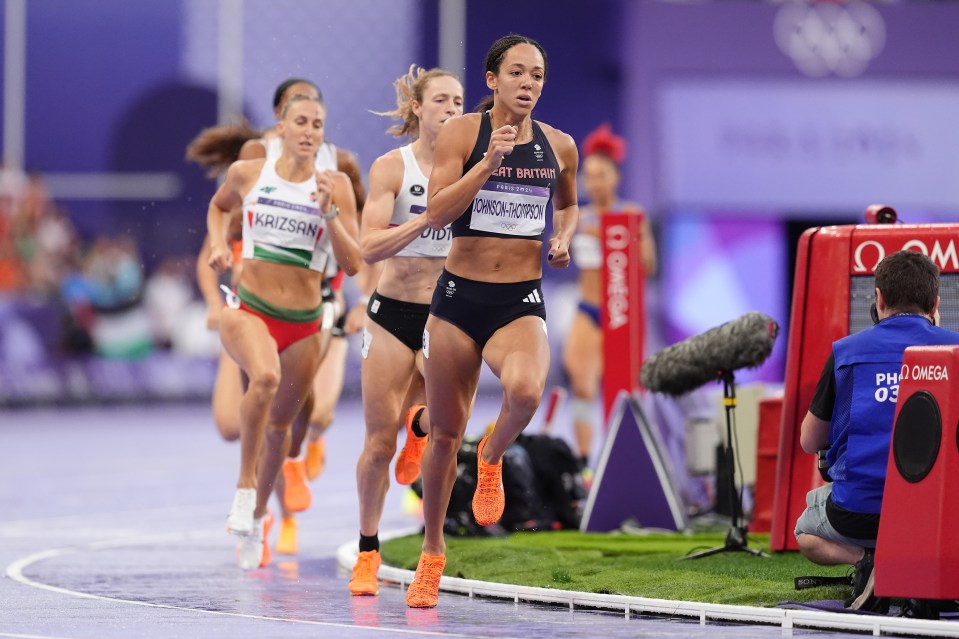 a group of women are running on a track and one of them is wearing a jersey that says ' great britain ' on it