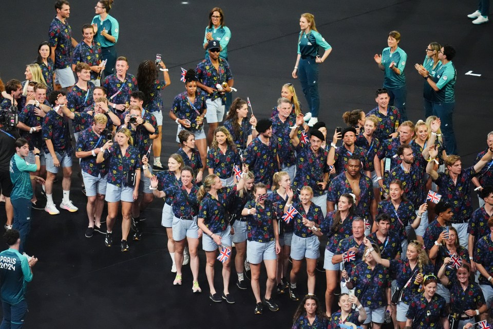 a large group of people are holding british flags