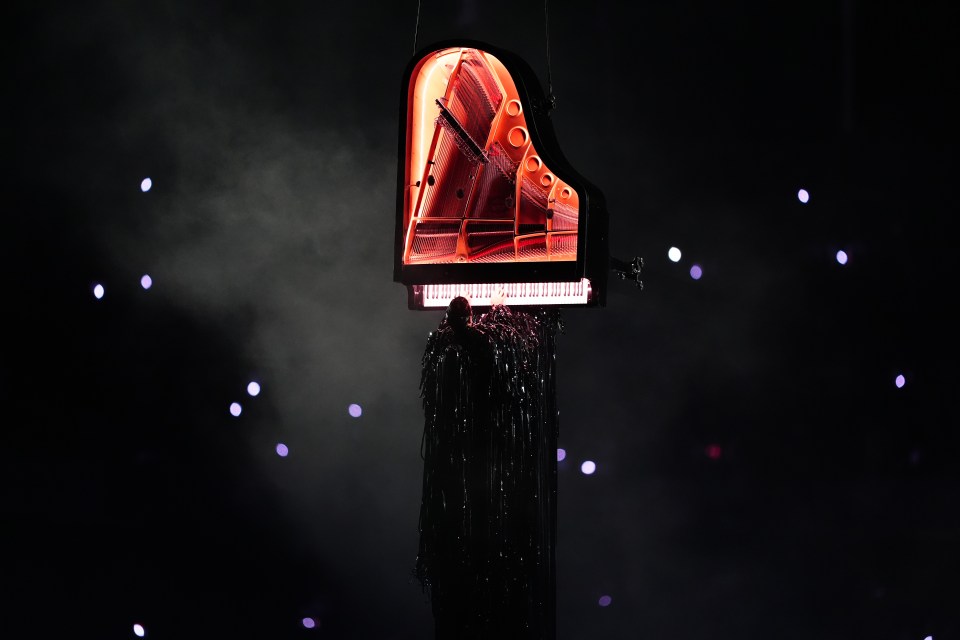 a piano is hanging from the ceiling in the dark