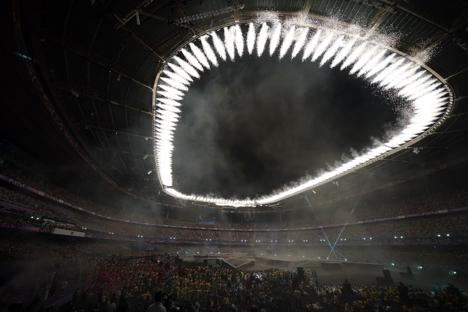 a stadium filled with people watching a fireworks display