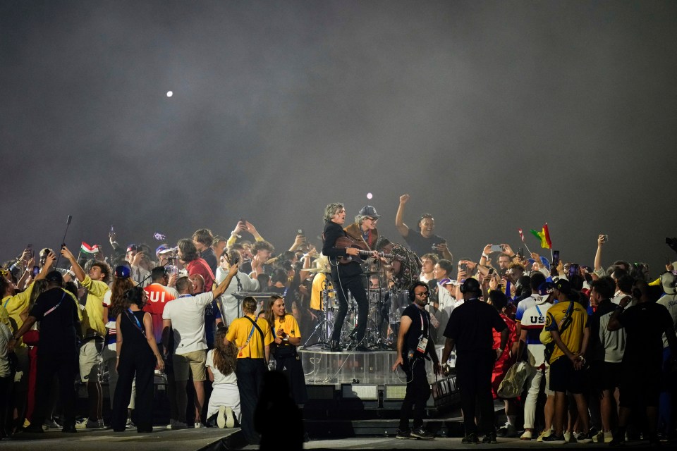 a man in a red ui shirt stands in front of a crowd