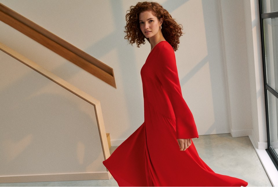 a woman in a red dress is walking down stairs