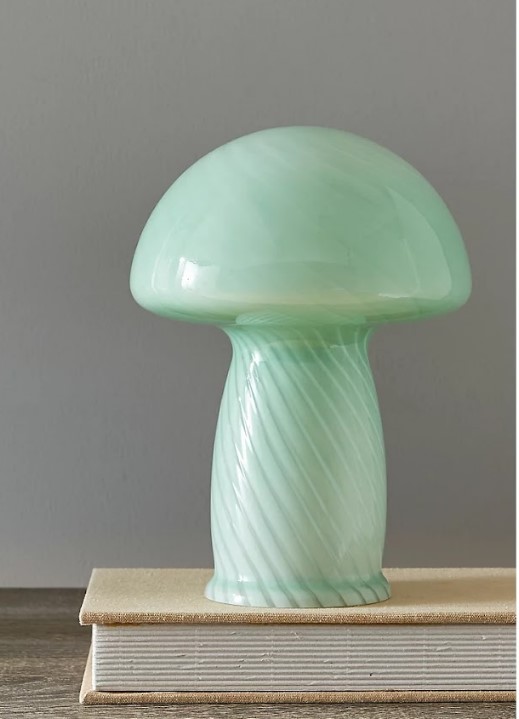 a green glass mushroom is sitting on top of a book