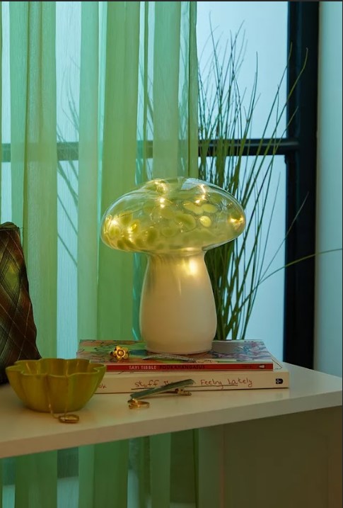 a mushroom lamp sits on a table next to a book called sweet feelings lately