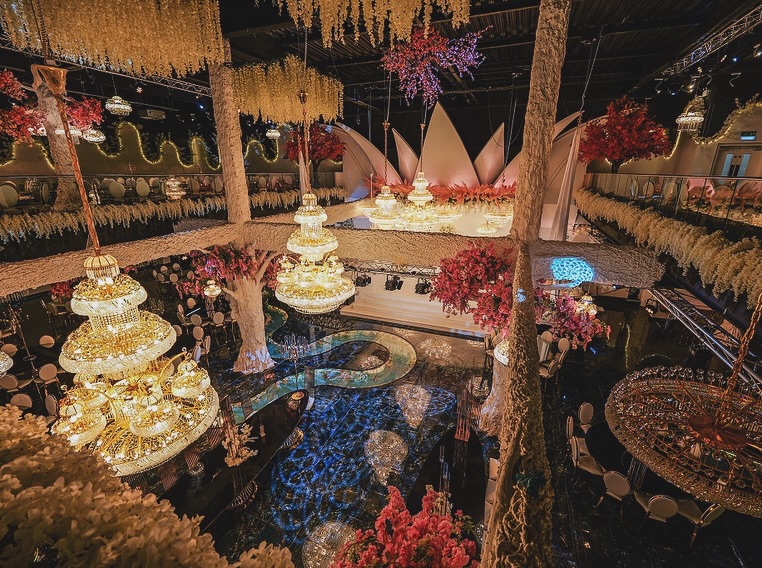 a large room with lots of chandeliers and flowers hanging from the ceiling