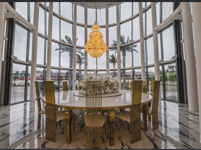 a dining room with a round table and chairs and a large chandelier