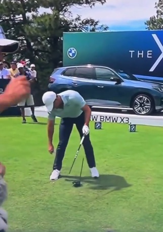 a man playing golf with a bmw x3 in the background