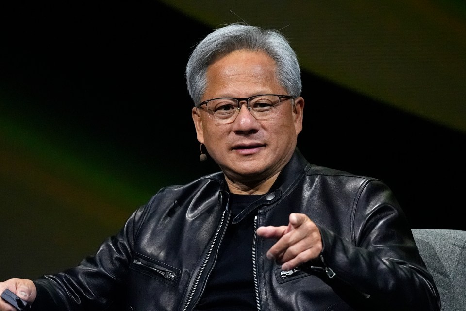 a man wearing glasses and a leather jacket is pointing