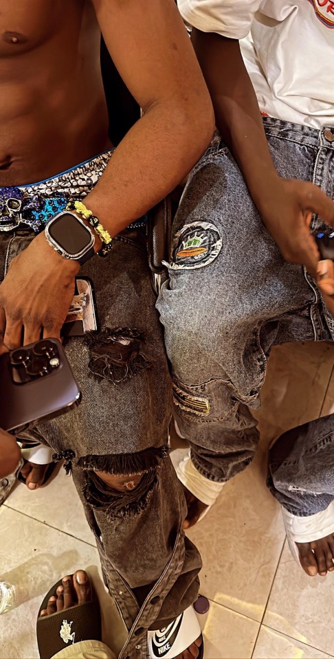 a man wearing nike sandals sits next to another man