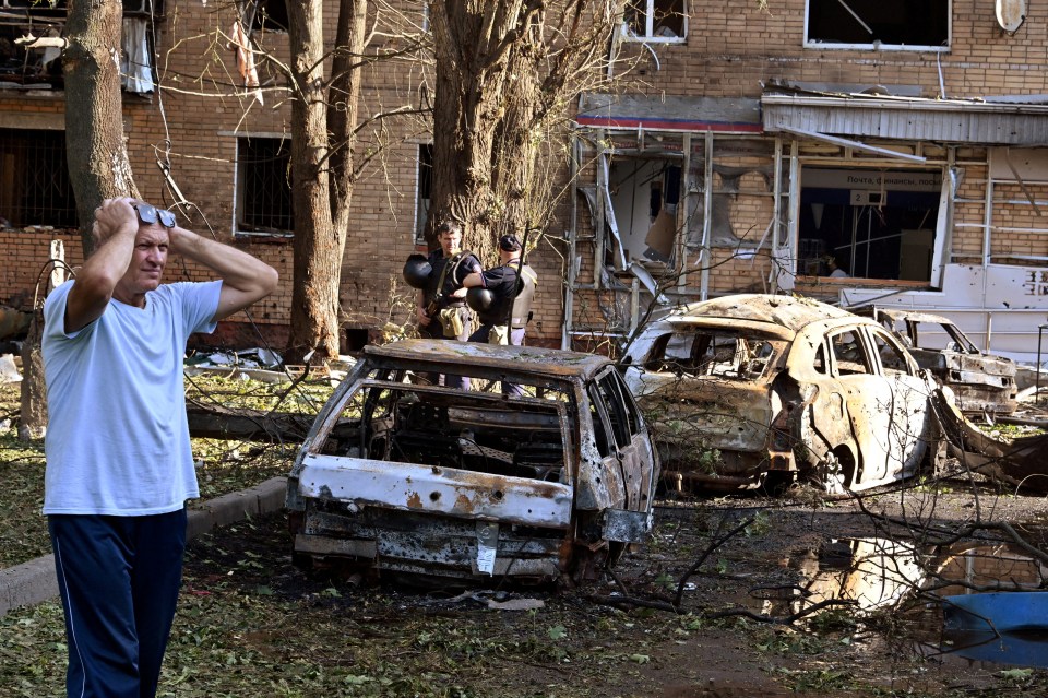 A Russian man reacts to missile debris, with many of his fellow residents evacuating