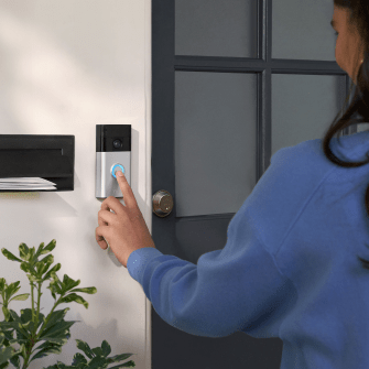 a person pressing a button on a ring doorbell