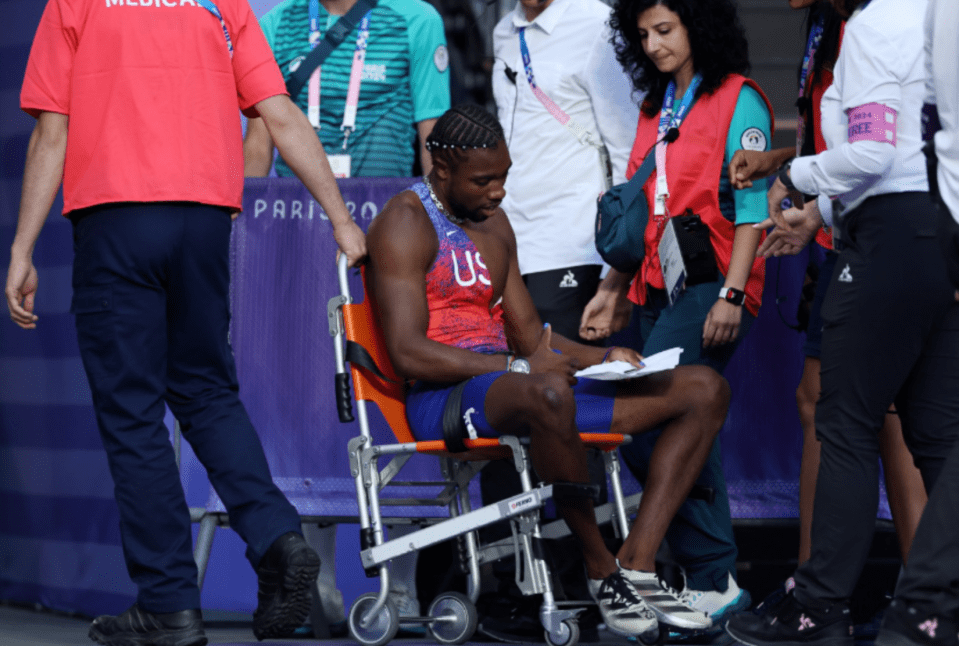 a man in a us shirt sits in a wheelchair