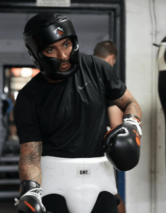 a man wearing boxing gloves and a gmt belt