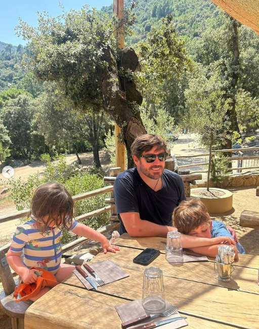 a man sits at a table with two children