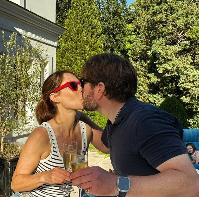 a man and woman kissing while holding glasses of champagne