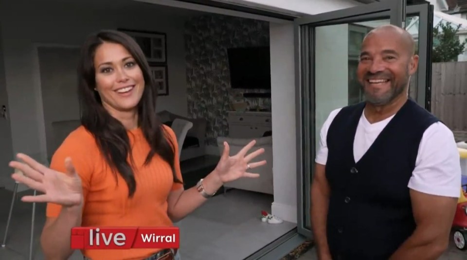 a man and a woman are standing next to each other in front of a sign that says live wirral