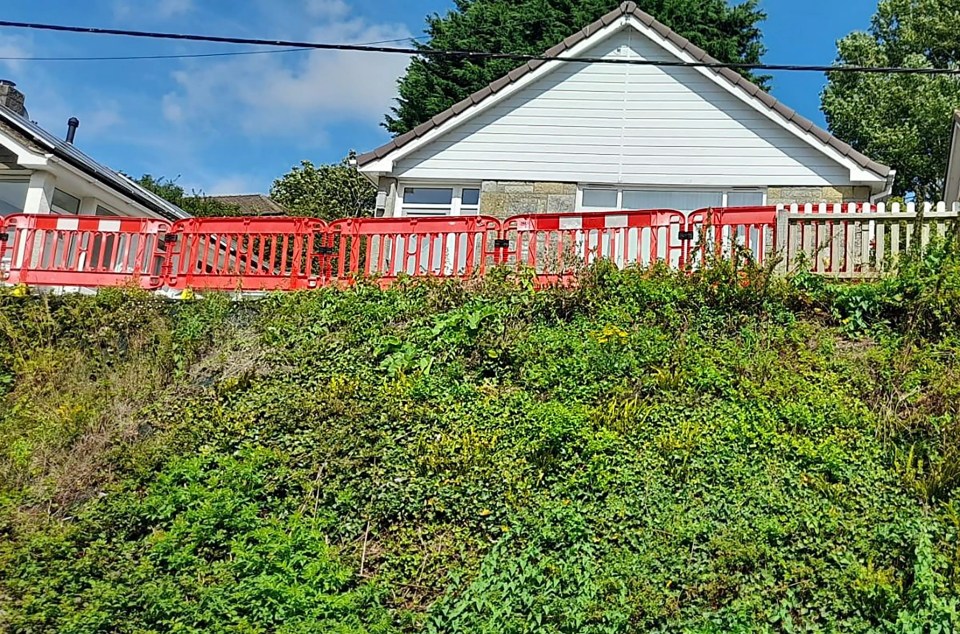 a picture of a house with a red fence in front of it