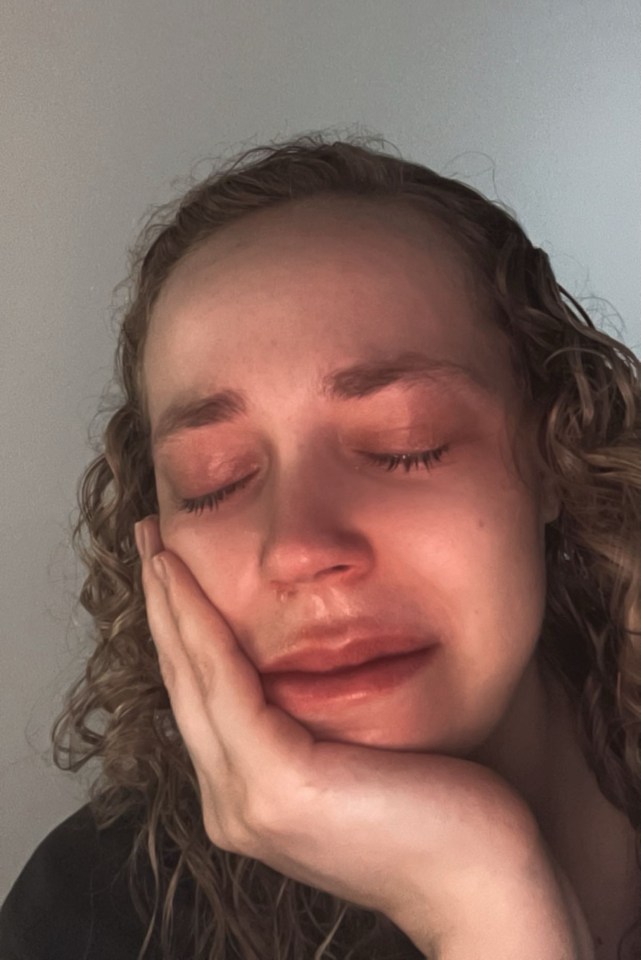 a woman is crying with her hand on her face