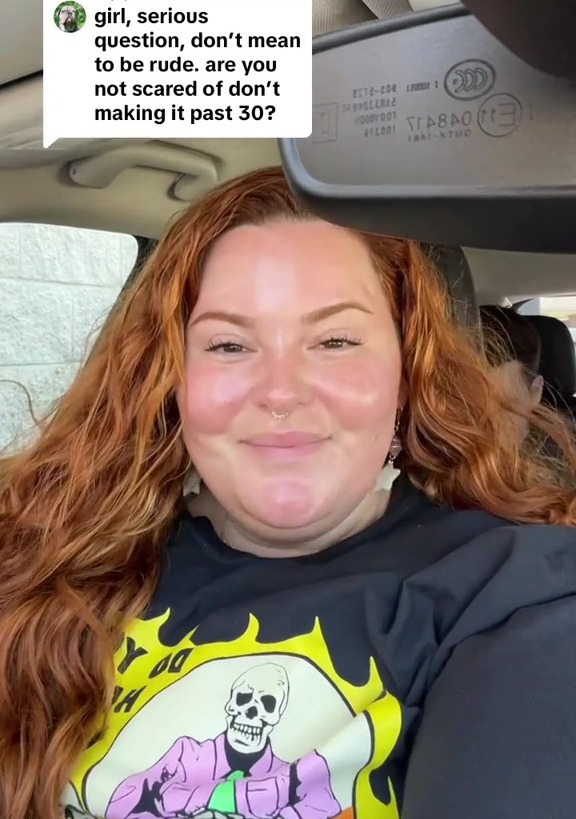 a woman sitting in a car with a skeleton shirt on