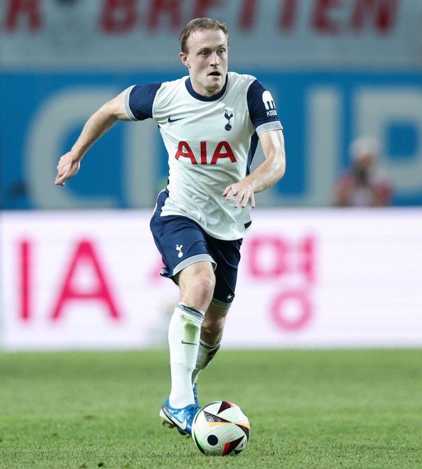 a soccer player wearing an aia jersey runs with the ball