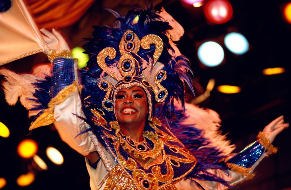 a woman in a colorful costume with the letter s on her head