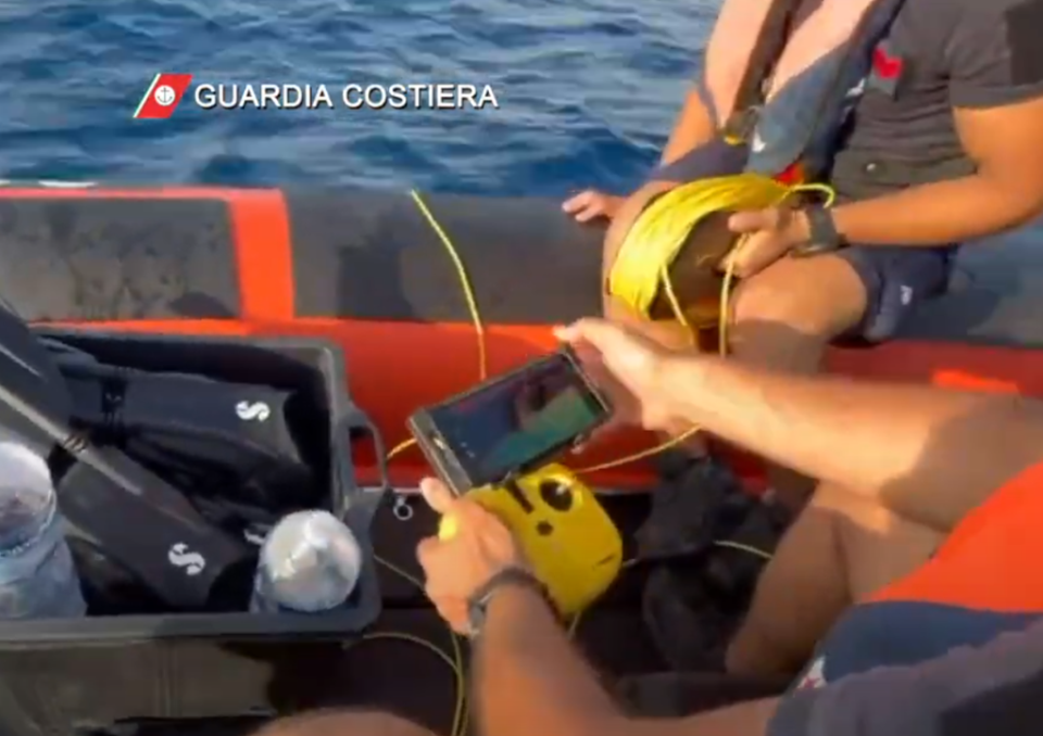 Rescuers operate the underwater drone robot from the surface