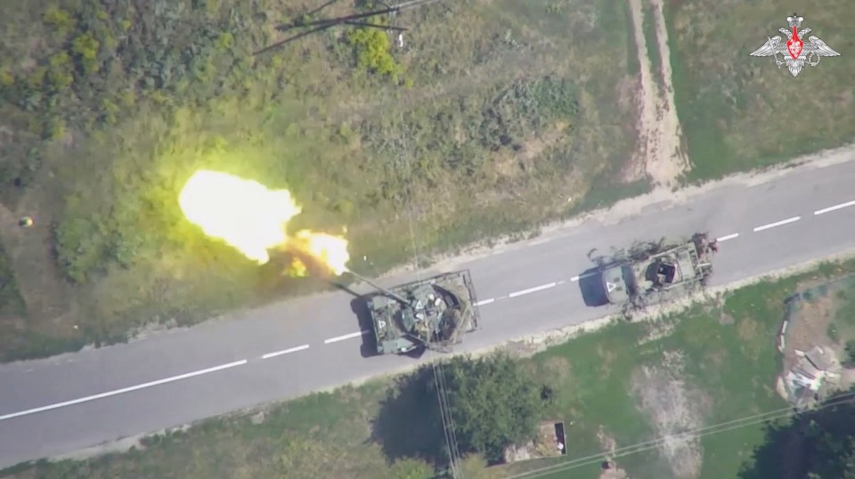 an aerial view of two military vehicles on a road