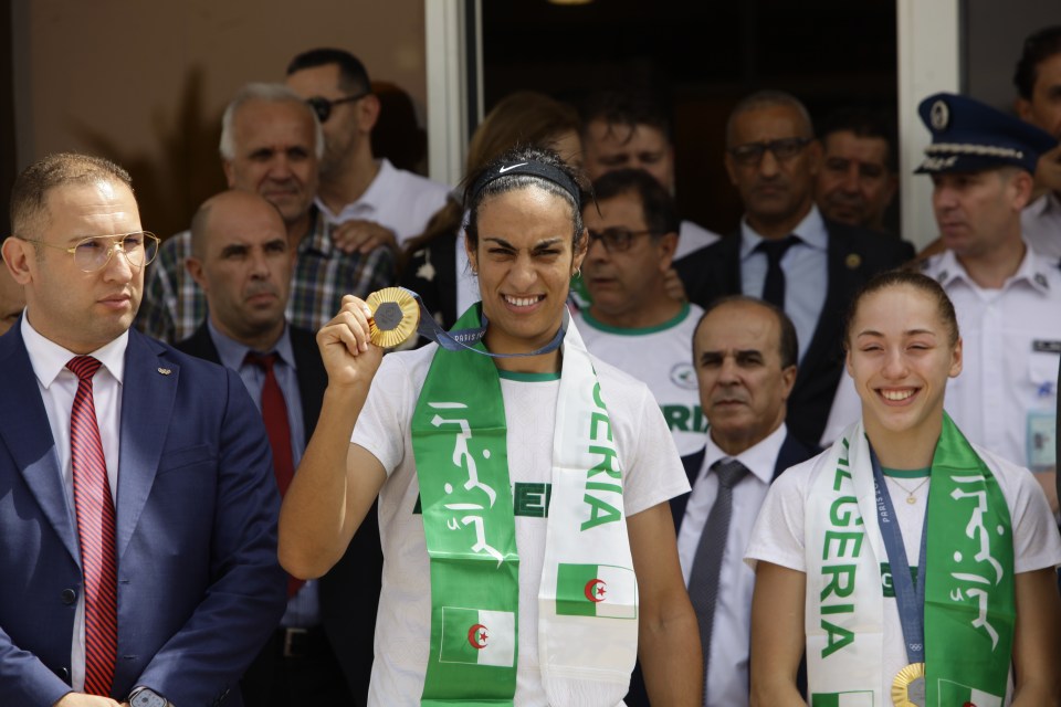 a woman wearing a scarf with the word algeria on it