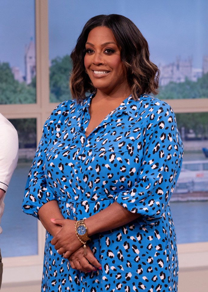 a woman in a blue leopard print dress is smiling