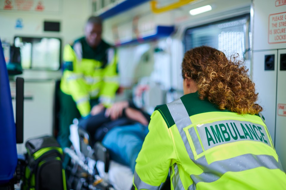 a woman in an ambulance with the word ambulance on her back