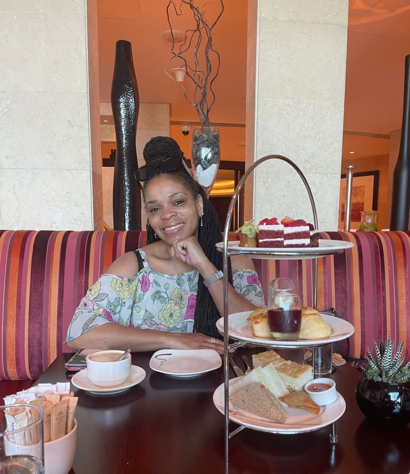 a woman sits at a table with plates of food on it