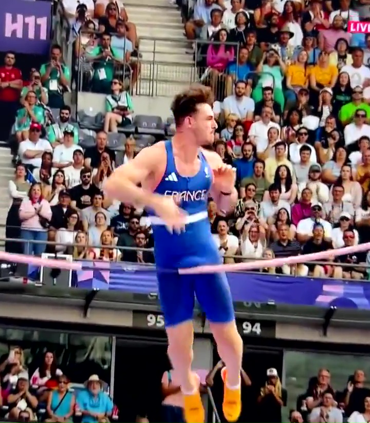 a man in a blue france tank top jumps over a rope