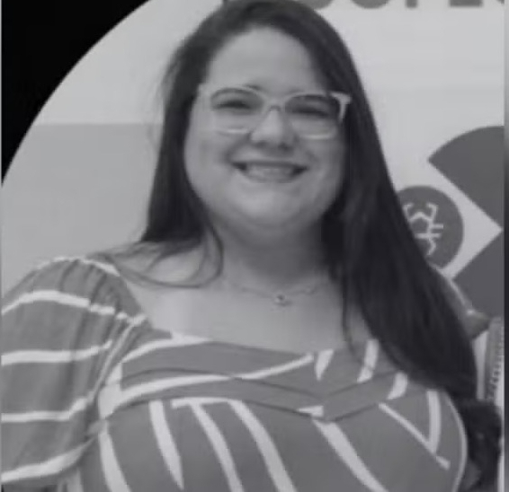 a woman wearing glasses and a striped shirt is smiling in a black and white photo .