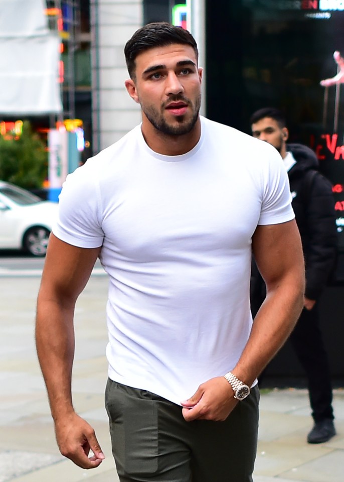 a man in a white t-shirt is walking down the street