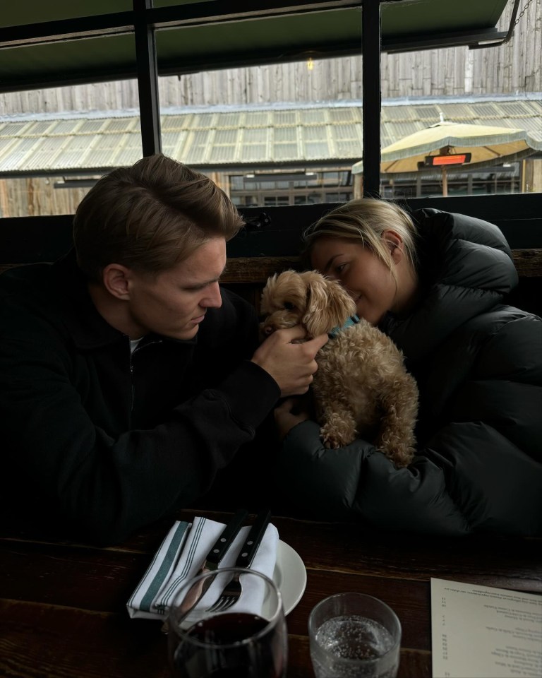 a man and a woman sitting at a table with a dog