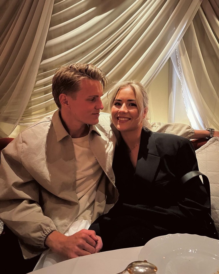 a man and a woman are posing for a picture while sitting at a table