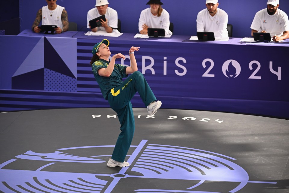 a person performing in front of a sign that says paris 2024