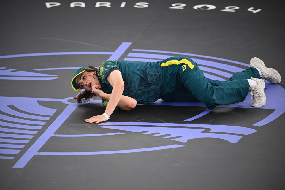 a person laying on the floor in front of a sign that says paris 2024