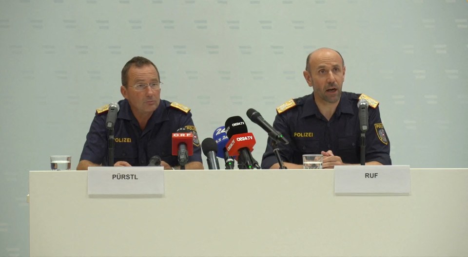 two police officers sitting at a table with microphones and a sign that says ruf