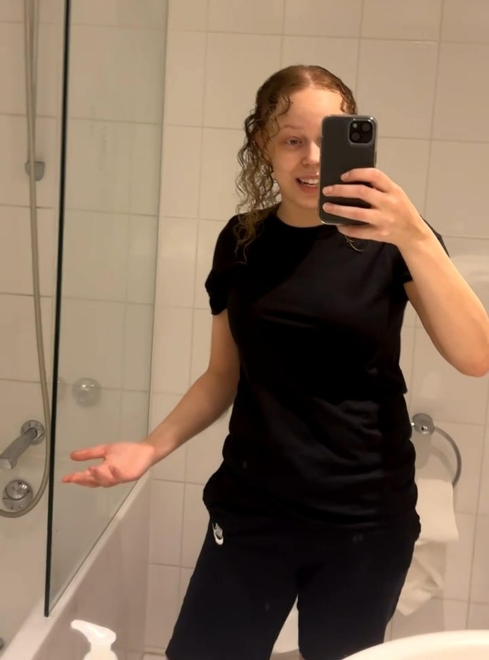 a woman taking a selfie with her phone in a bathroom