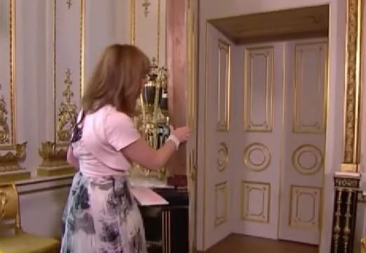 a woman is standing in a room with a sign that says a royal welcome the white drawing room