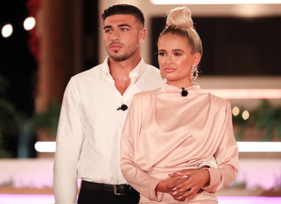 a man in a white shirt and a woman in a pink dress are standing next to each other